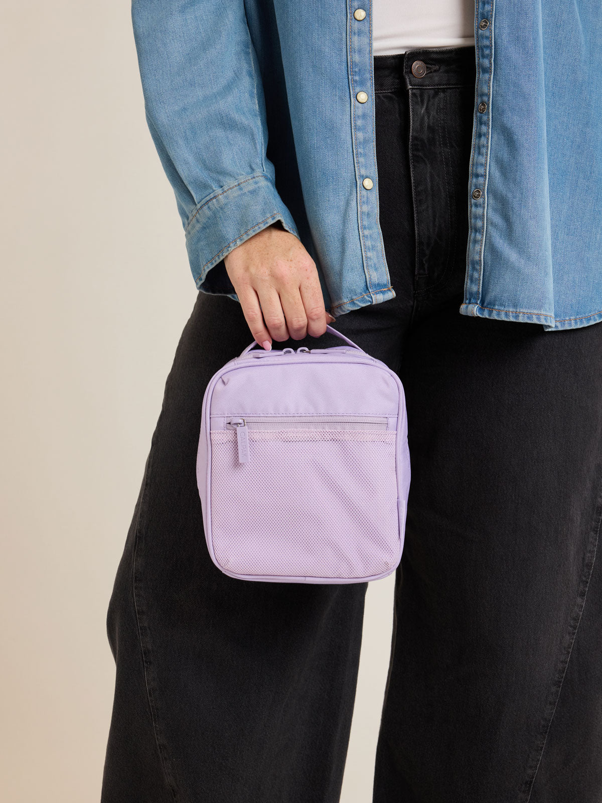 Model holding CALPAK Everything Cube in light purple Orchid; ACE2401-ORCHID