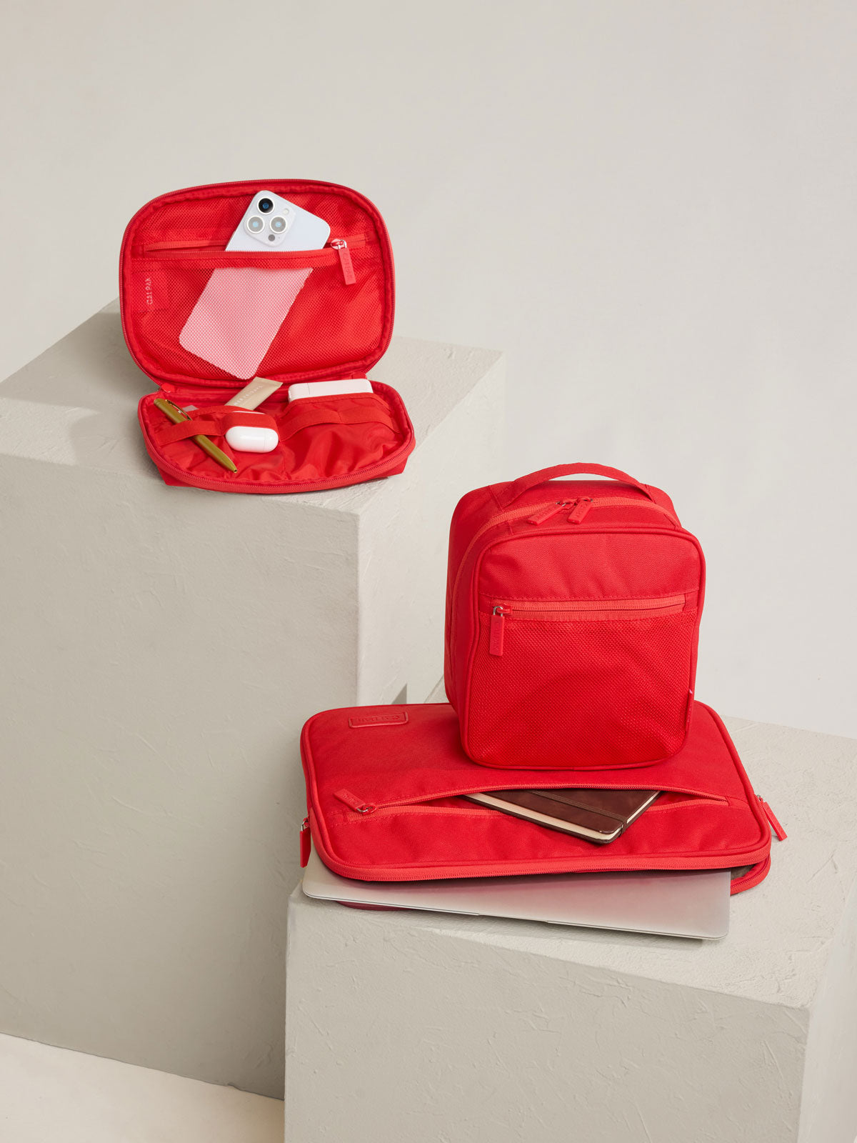 CALPAK Padded Laptop Sleeve 13-14" in red Tomato on a stool; ALP2213-TOMATO