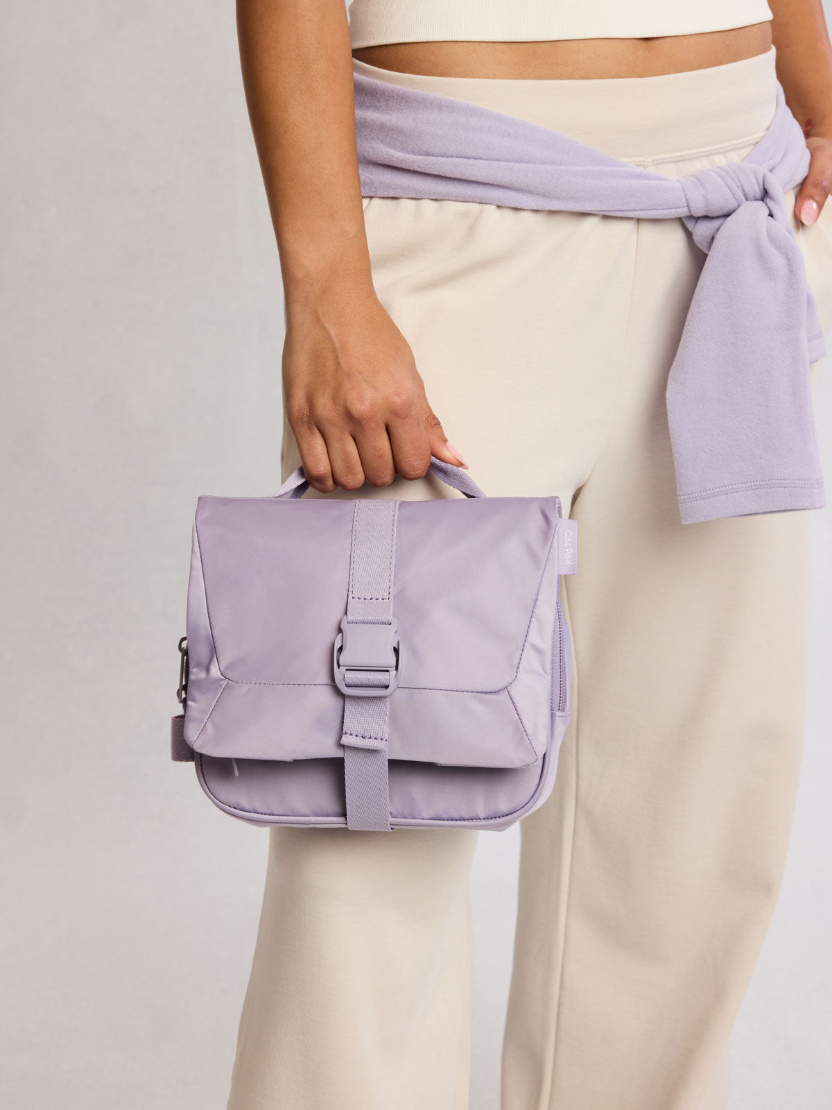 Model holding CALPAK Fit Hanging Dopp Kit in purple Iris; TFH2401-IRIS