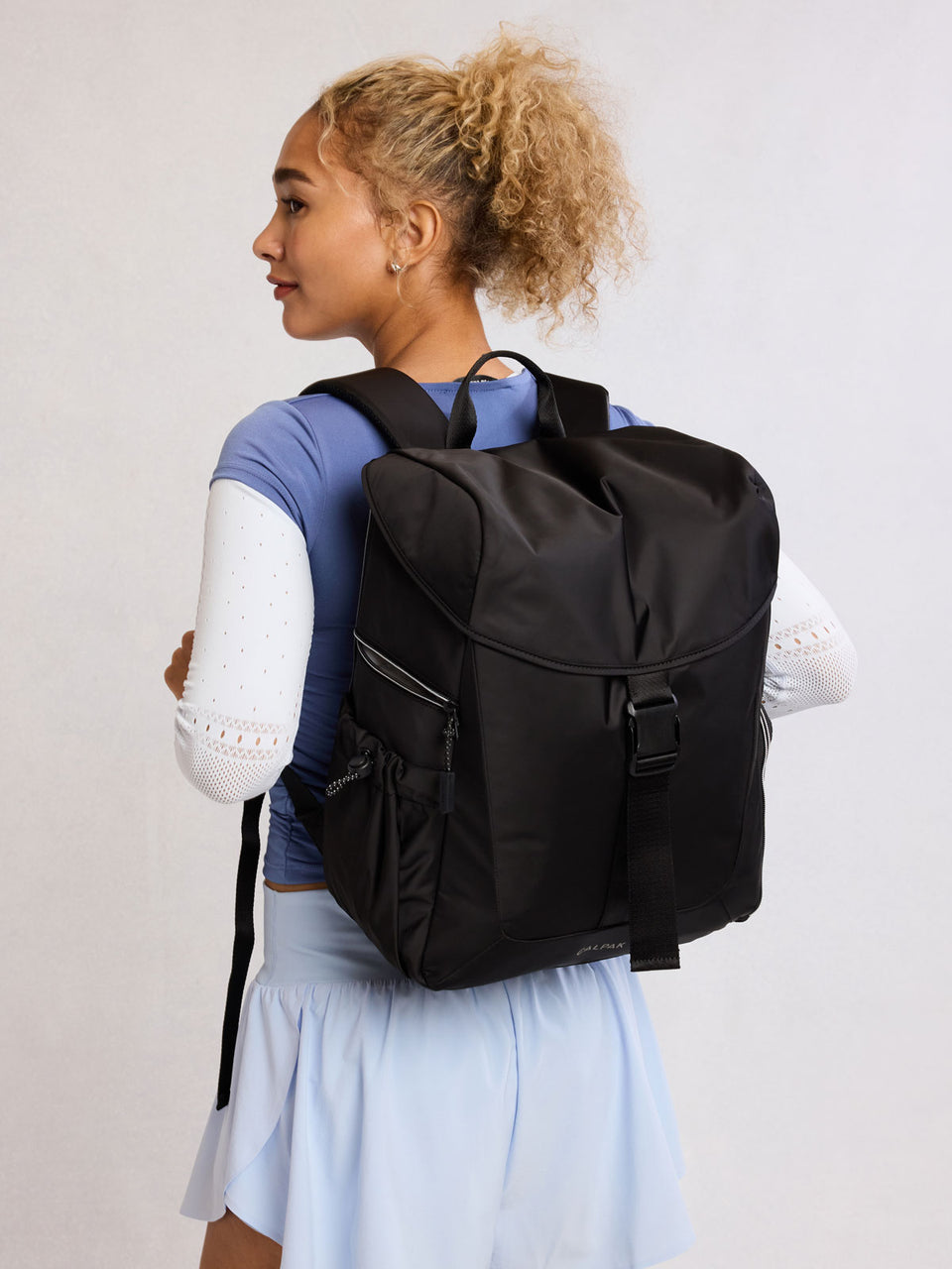 Model wearing CALPAK Fit Gym Backpack in Black front view with white background; BPF2601-BLACK