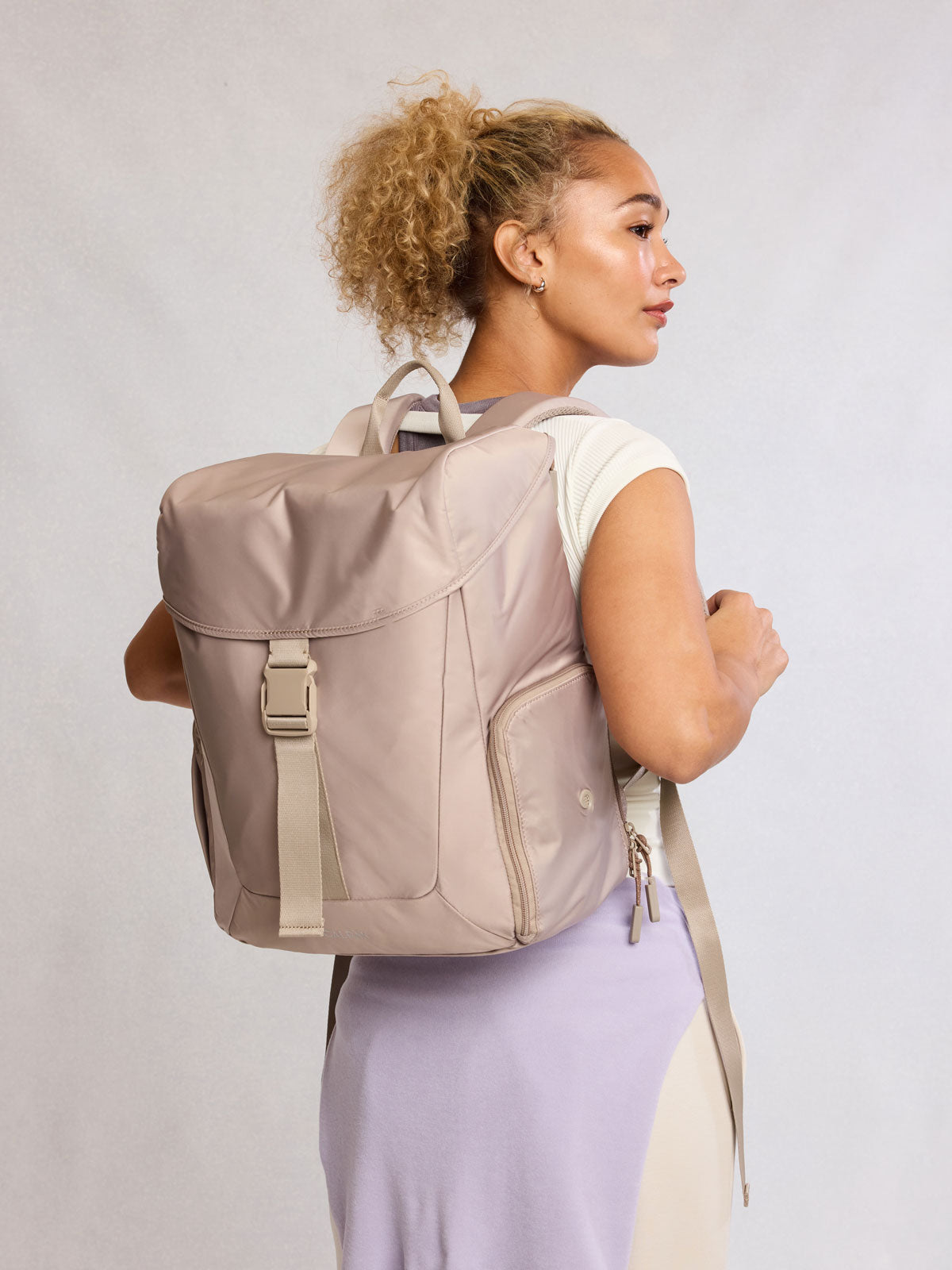 Model wearing CALPAK Fit Gym Backpack in beige Greige front view with white background; BPF2601-GREIGE