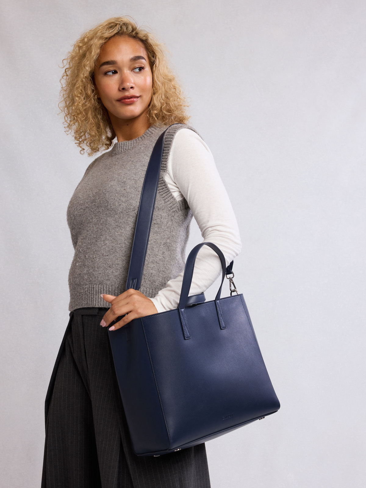 Woman wearing CALPAK Haven 15" Laptop Tote in dark blue Navy;ATS2501-NAVY