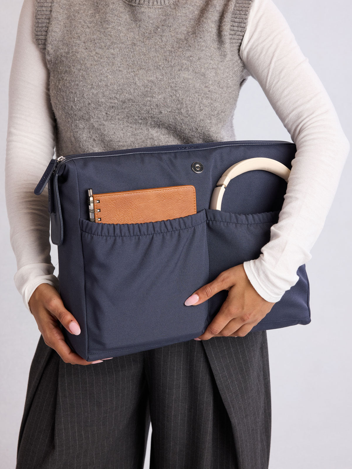 Modle holding the removeable insert of CALPAK Haven 16" Laptop Tote in dark blue Navy; ATO2102-NAVY