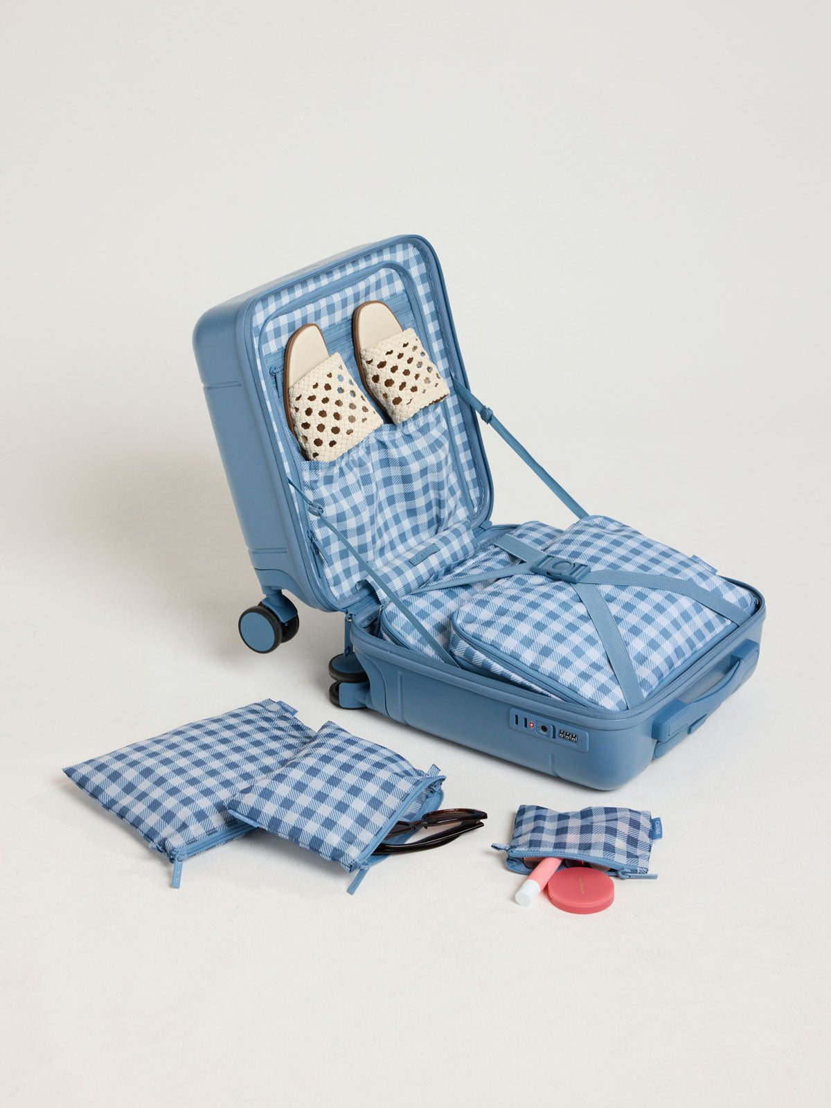Opened view with items in the CALPAK Hue Mini Carry On in light blue French Blue with Gingham interior; LHU1014-FRENCH-BLUE