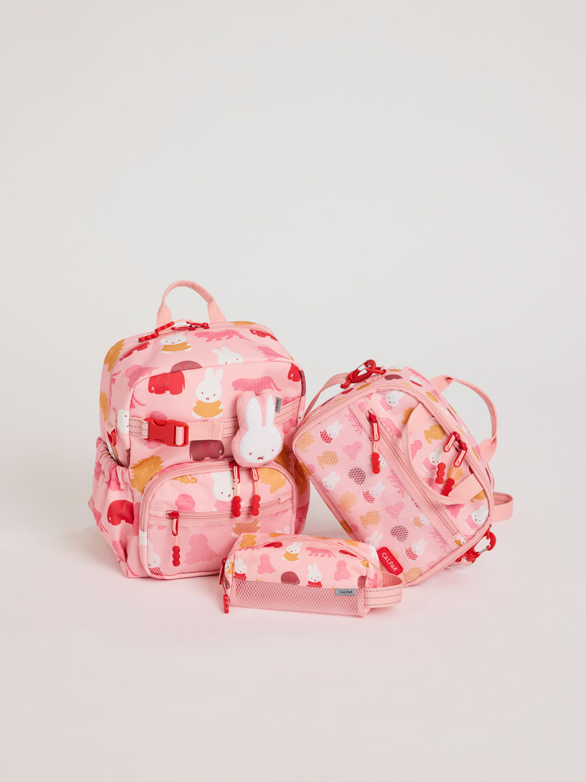 Colorful CALPAK + Miffy Kids Essentials Set with children's Small backpack, lunch bag , pencil case set on a white background with pink accents and Miffy with other animals; BCKS5000-MIFFY-PINK-ZOO-TRIP