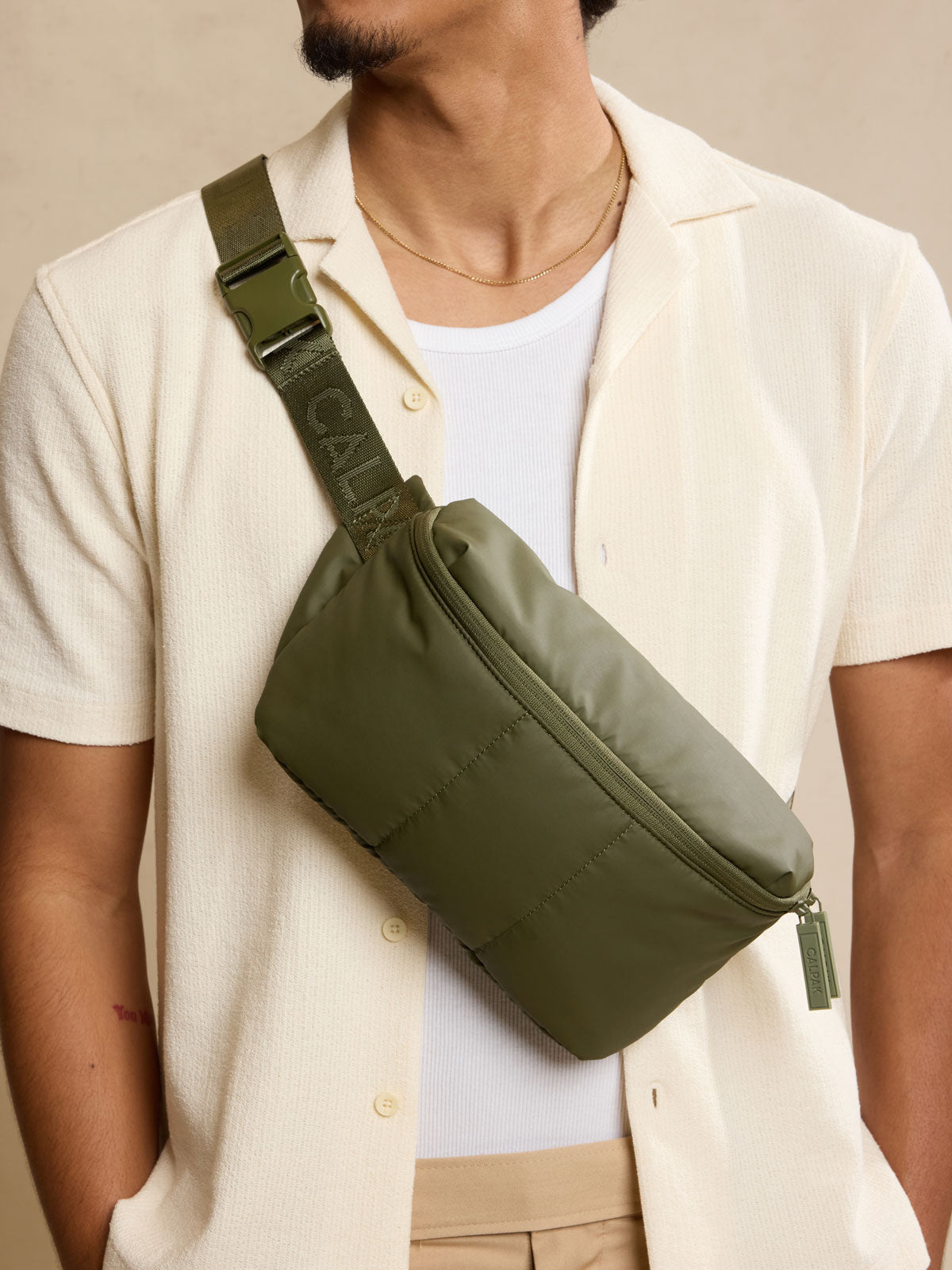 Model wearing CALPAK Luka Belt Bag in dark green Pine front view; BB1901-PINE