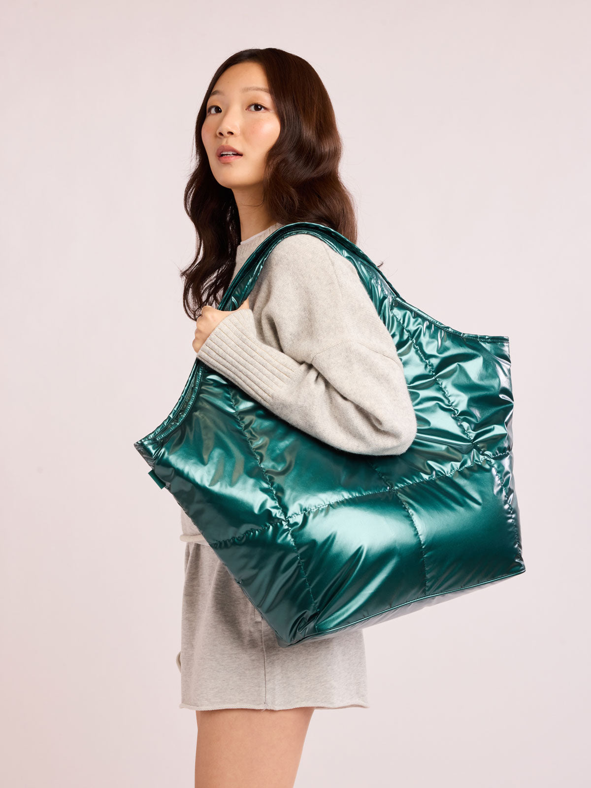 Woman wearing CALPAK Luka Everything Tote in dark green shiny Kale; AET2601-GLAZED-KALE