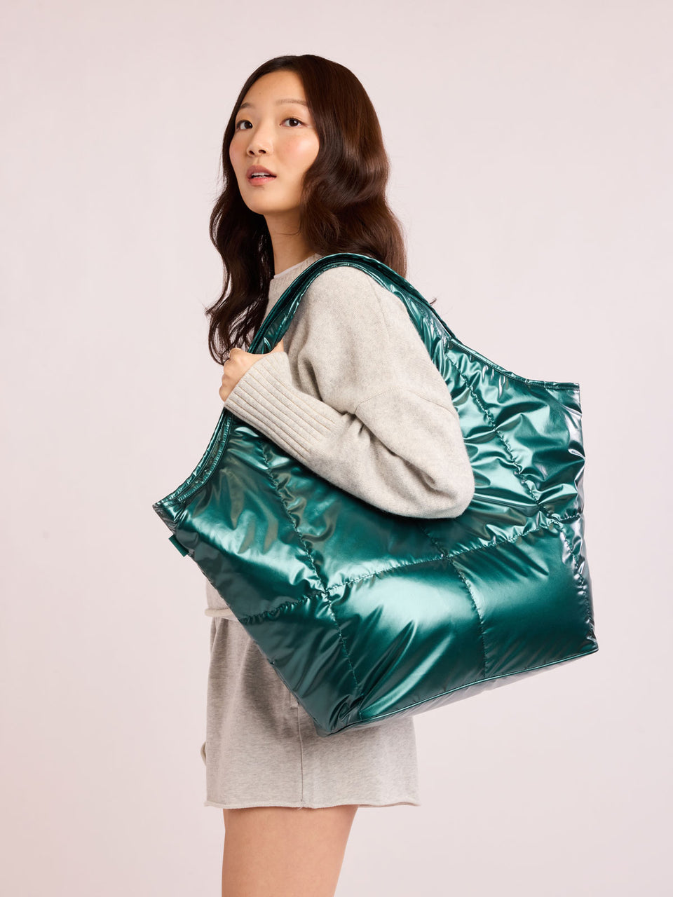 Woman wearing CALPAK Luka Everything Tote in dark green shiny Kale; AET2601-GLAZED-KALE