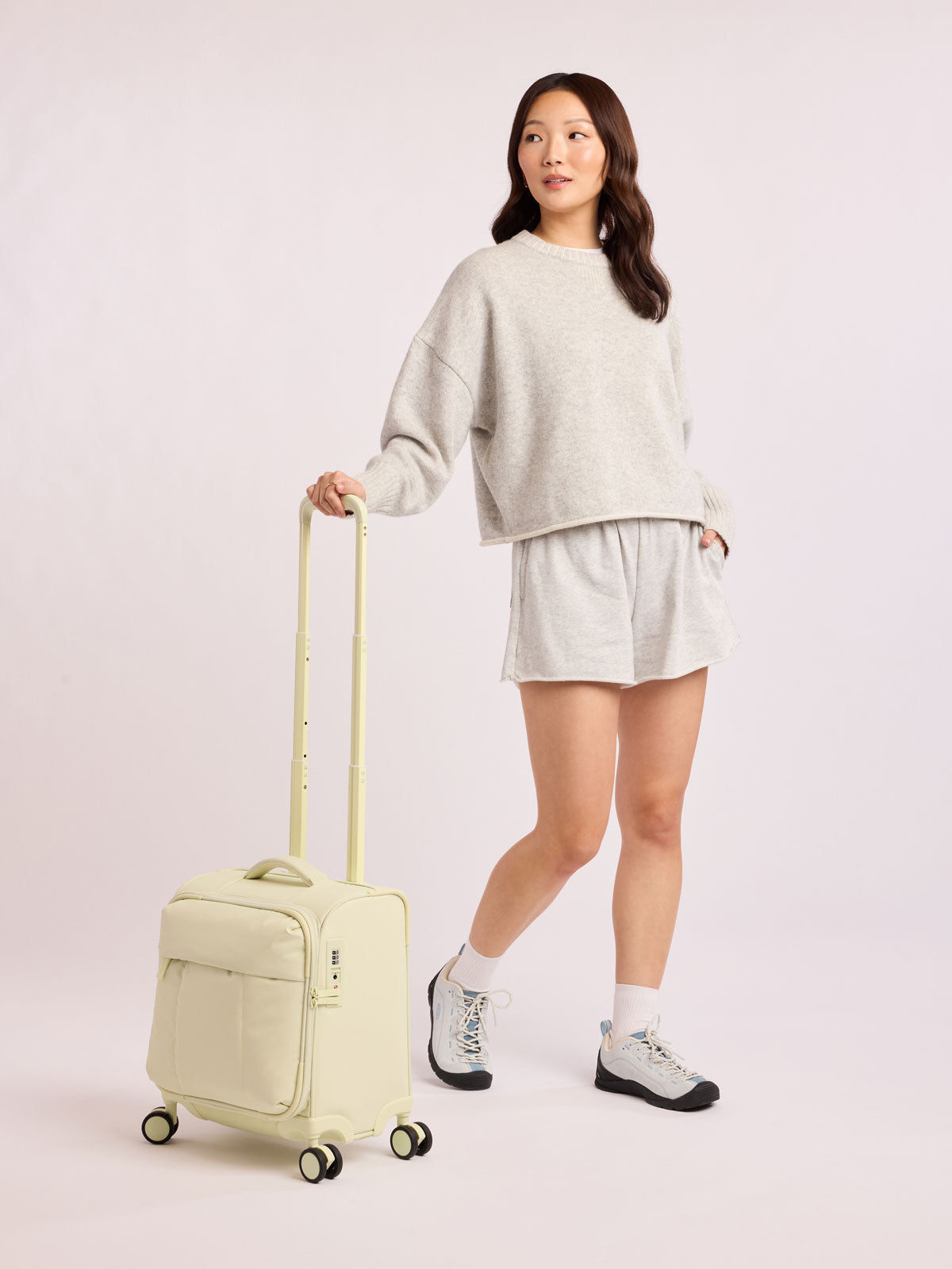 Model with CALPAK Luka Soft-Sided Mini Carry On Luggage in light green Celadon with spinner wheels and handle; LSM1014-CELADON