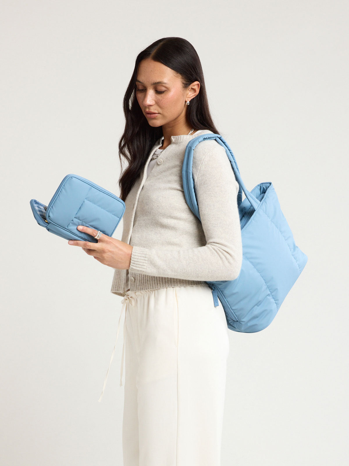 Woman wearing the CALPAK Luka Mini Tote in light blue French Blue; ALM2401-FRENCH-BLUE
