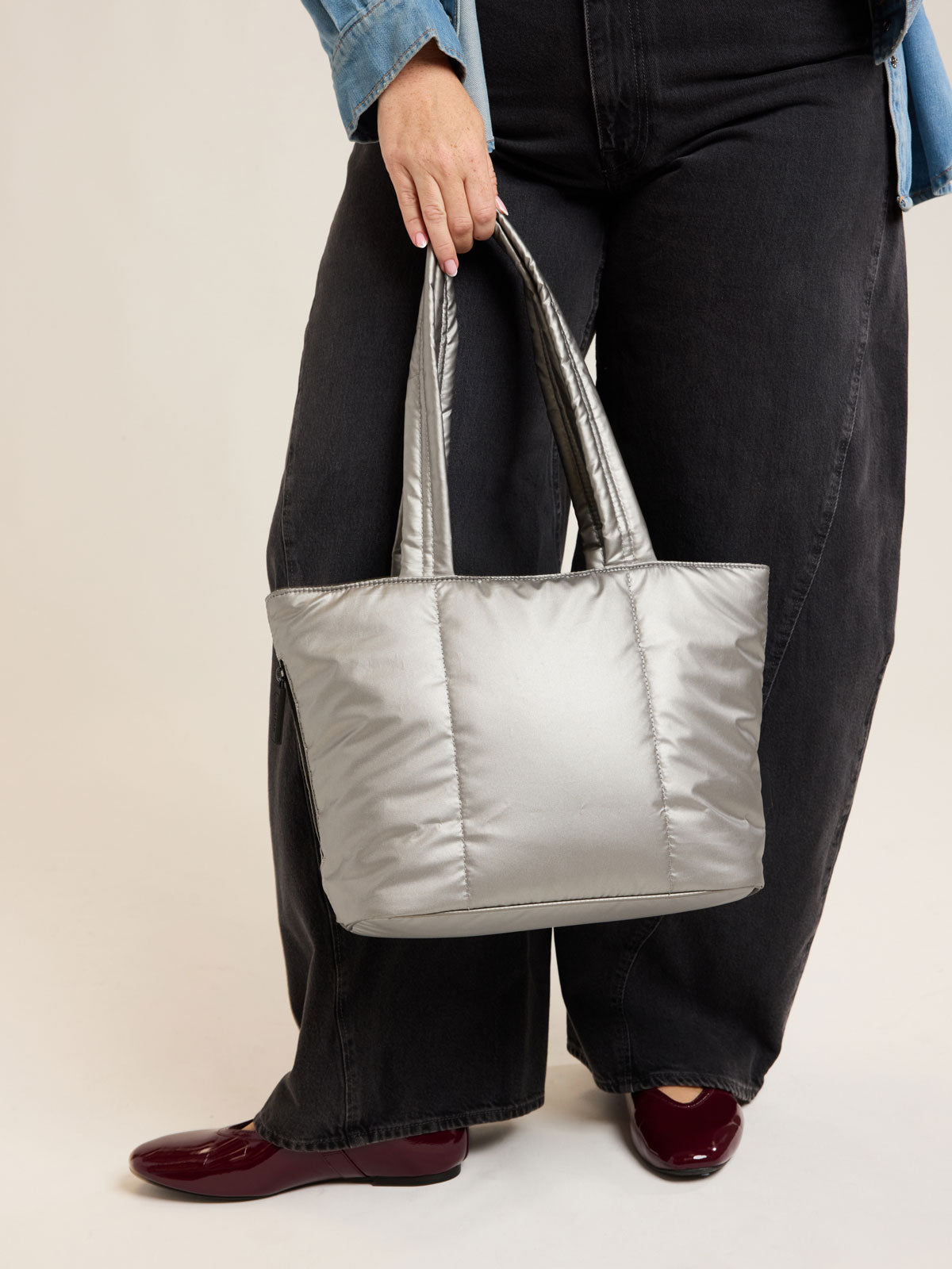 Model holding CALPAK Luka Mini Tote in metallic Gumetal grey a white background; ALM2401-GUNMETAL