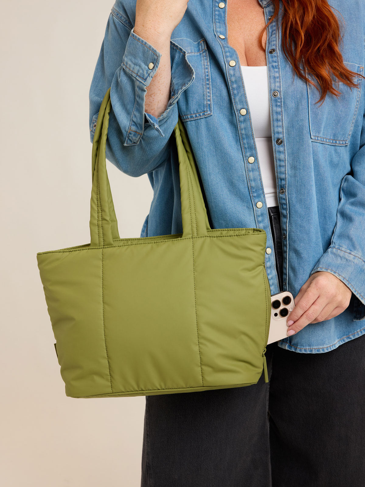 Model holding CALPAK Luka Mini Tote in green Pistachio on a white background; ALM2401-PISTACHIO