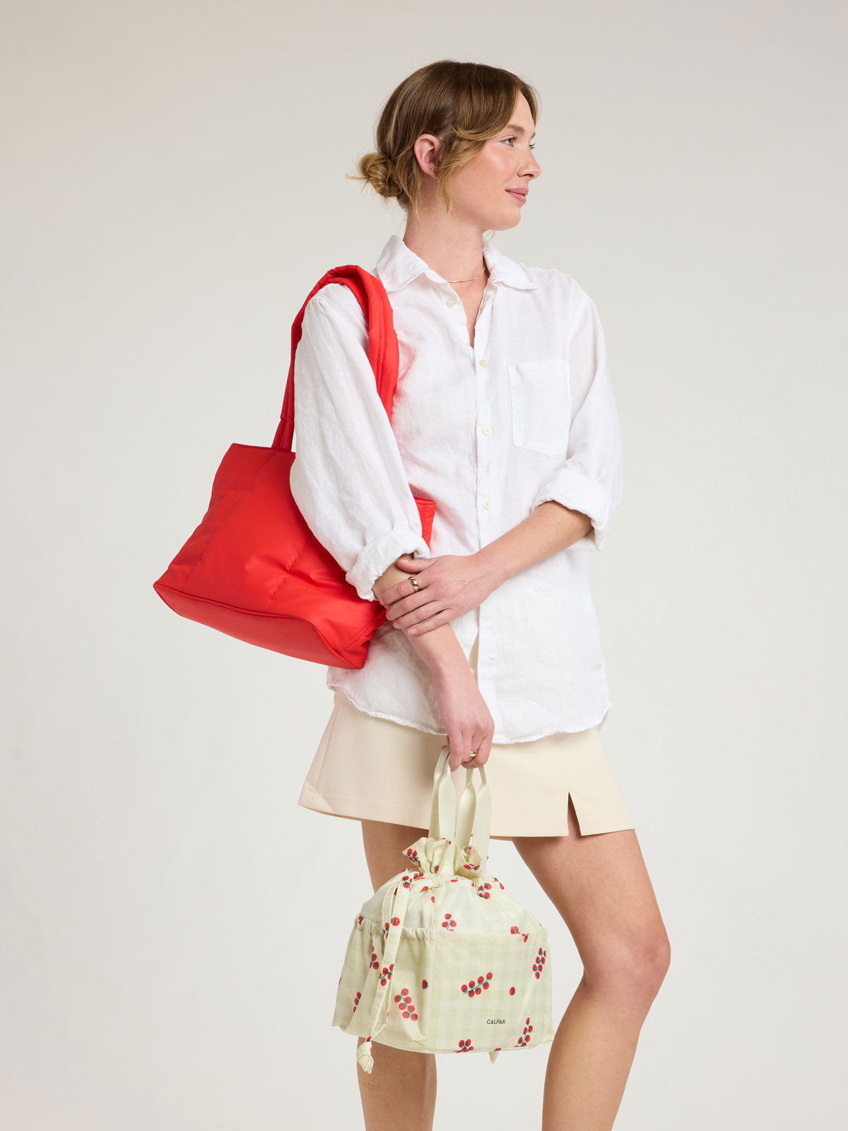 Model wearing CALPAK Luka Mini Tote in red Tomato; ALM2401-TOMATO
