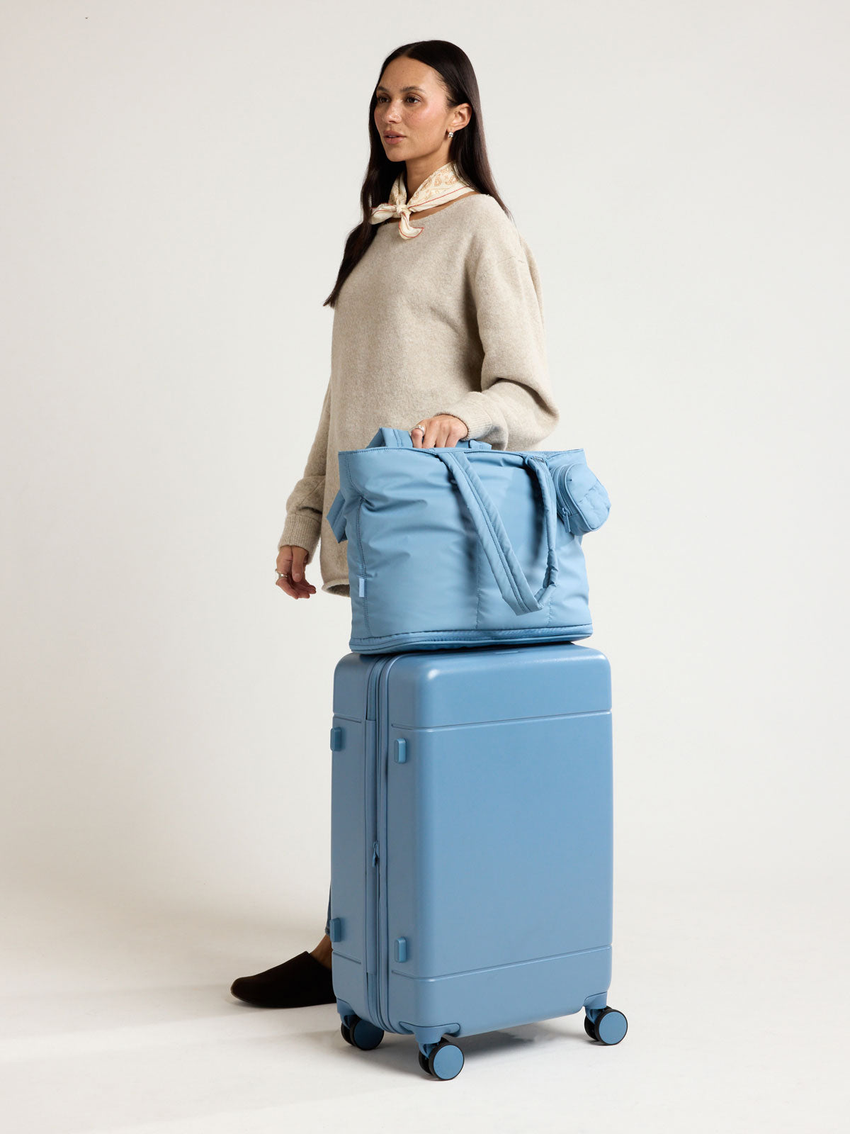 Woman with CALPAK Luka Expandable Tote in light blue French Blue; ALT2201-FRENCH-BLUE