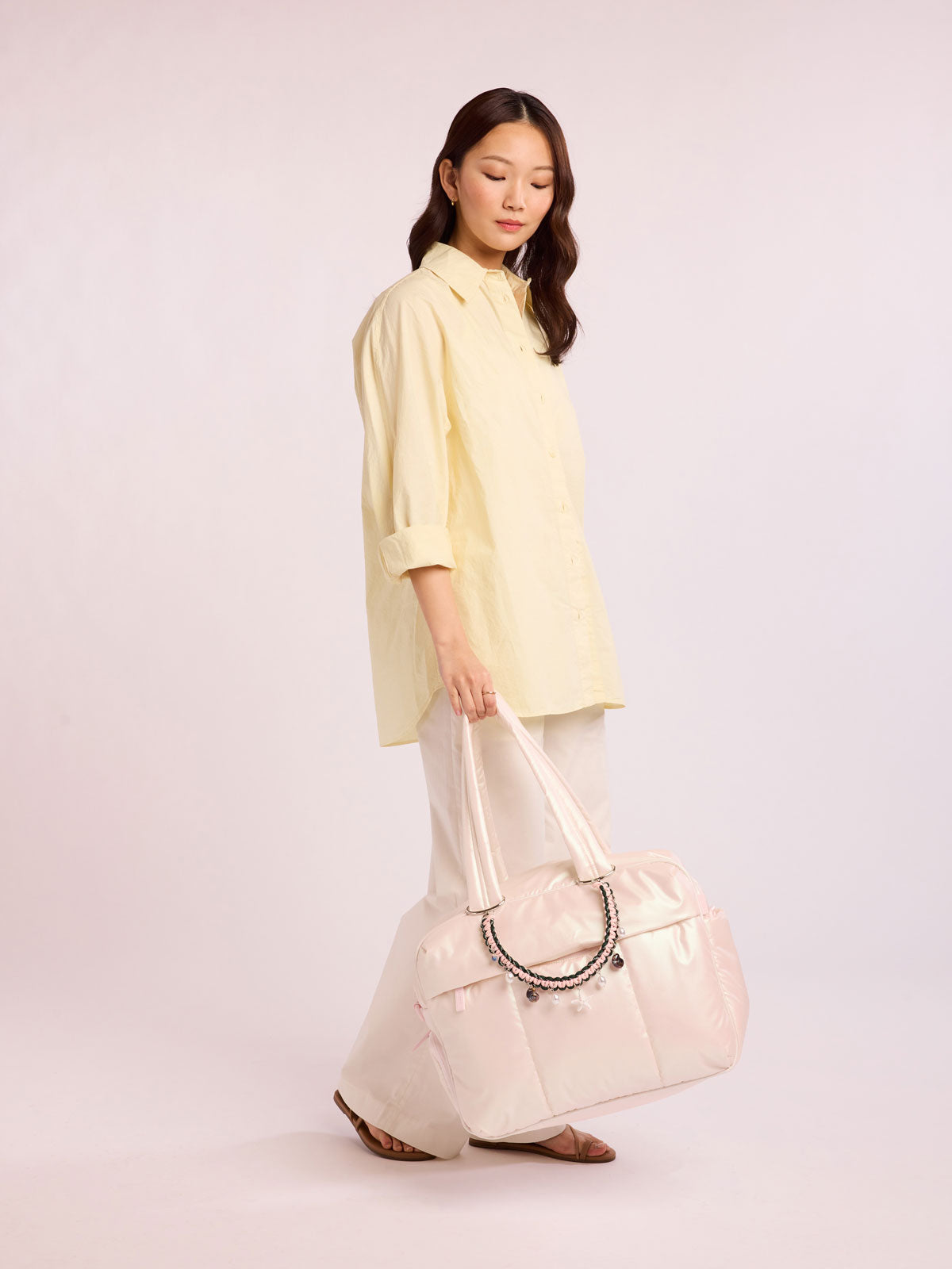 Woman with bag that has CALPAK Rope Bag charm in green and pink rope with sea life charms; BCR2601-SHELL-LIFE