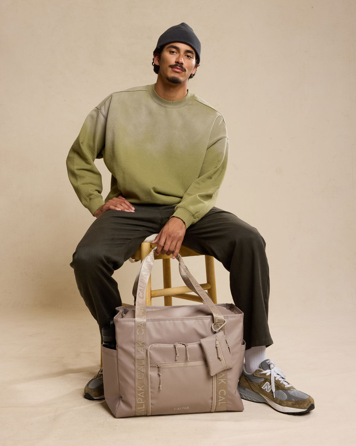 Model with CALPAK Terra 35L Tote in beige Stone front; TTO2401-STONE
