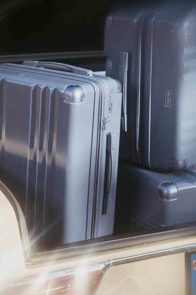 CALPAK Ambeur collection in Indigo in the trunk of a car 